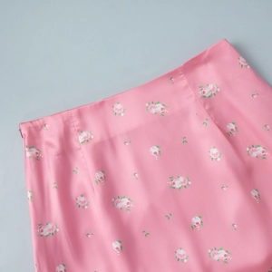 Detail of pink floral satin skirt featuring silk-like fabric and hidden zipper closure