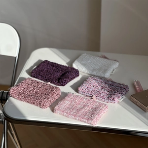 Detailed view of assorted tweed mini pouches with zipper closure and logo label