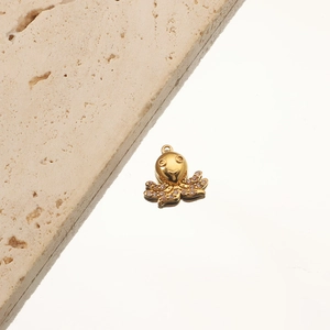 Detail of 18K gold-plated octopus pendant with crystals on a textured stone background