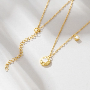 Detail of 925 silver gold flower necklace with white shell pendant and zircon stone