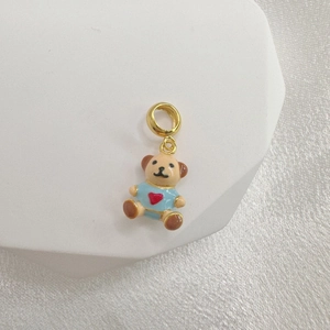 S925 silver teddy bear pendant with blue heart shirt on geometric display stand