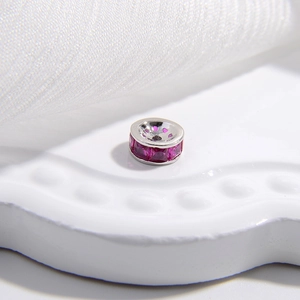 Vista macro di un distanziatore in argento S925 con pietre di zirconi rosa rubino