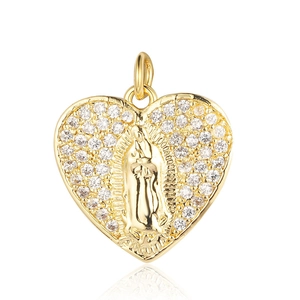 Detailed close-up of a heart-shaped golden pendant with religious Virgin Mary engraving