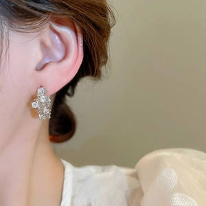 Macro side view of silver earrings featuring irregular cubic zirconia cluster stones