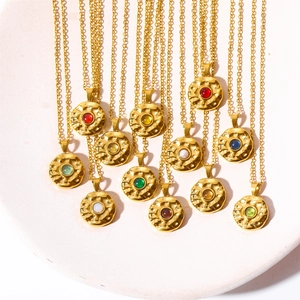 Close-up of gold stainless steel coin pendants with colorful birthstones and hammered texture
