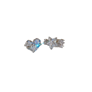 Asymmetric silver heart and star ear clips featuring shimmering zircon stones on white backdrop