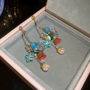 Detailed close-up of crystal flower tassel earrings with blue petals and colorful beads