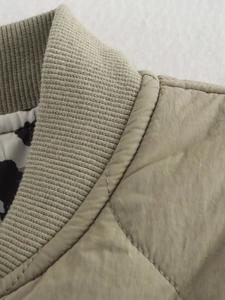 Detail of olive quilted jacket featuring ribbed knit collar and high-quality stitching