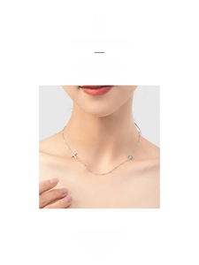 Detailed view of S925 sterling silver evil eye and cross pendants on minimalist chain