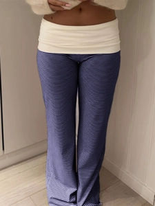 Detail of blue and white striped trousers featuring a contrasting off-white fold-over waistband