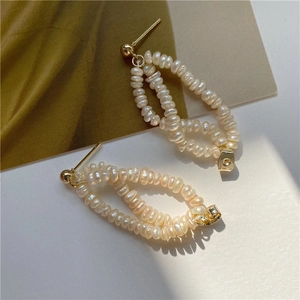 Close-up of vintage baroque natural freshwater pearl earrings with golden metal details