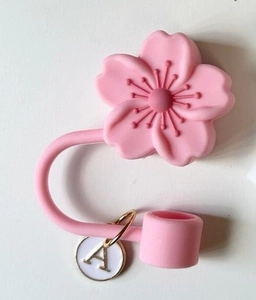 Detail of pink silicone cherry blossom straw cover with gold letter A pendant