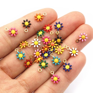 Colorful stainless steel daisy flower charms for DIY jewelry making held in a hand