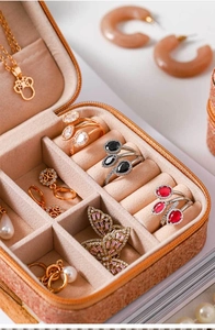 Macro view of beige leather jewelry box with velvet compartments for rings and earrings