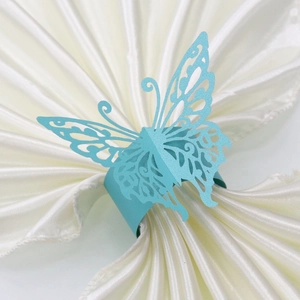 Detail of light blue butterfly paper napkin ring with pearl finish on white satin