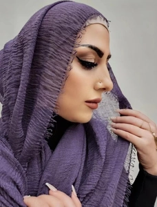 Purple crinkle cotton linen scarf with frayed edges worn by a model in a studio