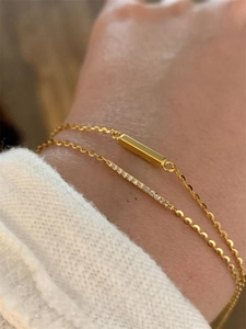 Macro shot of gold geometric link bracelets featuring one polished and one paved bar