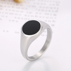 Detailed side view of polished stainless steel ring with a round black enamel inlay