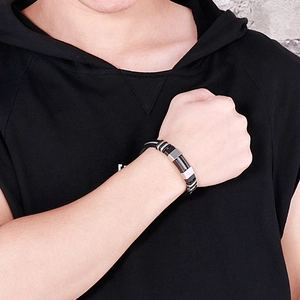 Detail of men's black silicone bracelet with brushed stainless steel clasp on wrist