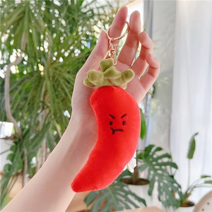 Macro shot of red chili plush keychain with metal ring and embroidered angry expression