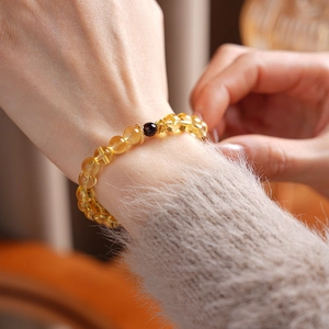 Detail of Citrine and Garnet beaded flower bracelet worn on a female wrist