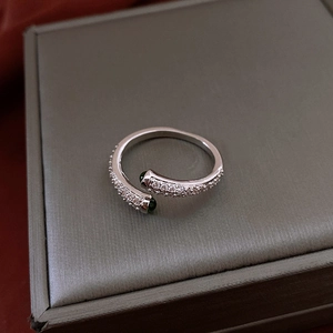 Détail macro d'une bague réglable en argent avec zircone et pierres précieuses vertes