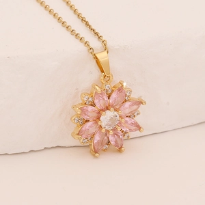 Gold-tone necklace with pink zircon flower pendant and crystal leaf accents on stone
