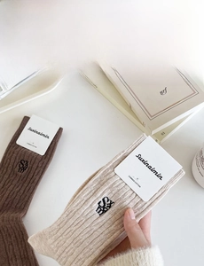 Détail de chaussettes en coton peigné avec broderie SXAM en couleurs café et avoine