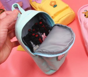Mini backpack-style canvas pencil case in light blue featuring a cute cartoon animal patch