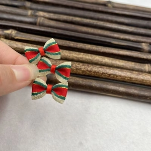 Detailed close-up of three red green and gold striped Christmas ribbon bows with small bells