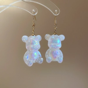 Macro shot of bear earrings with holographic resin finish and gold hooks