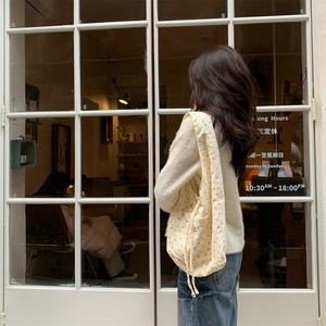 Detail of floral corduroy shoulder bag with drawstring closure on a female model