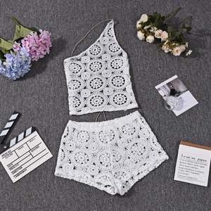 Dettaglio del motivo floreale all'uncinetto bianco su top a fascia e shorts a vita alta