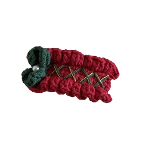Cute Christmas knitted hair clip with red wool, green bow, and pearl on white background