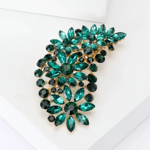 Detail of emerald green crystals on a gold vintage brooch, professional macro shot