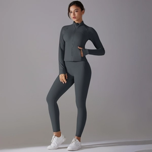 Detail of dark gray yoga set featuring zip-up jacket with thumbholes and high-waist leggings