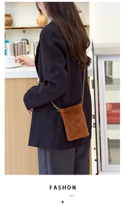 Detail of caramel brown plush mini crossbody bag with a slim gold metal chain strap