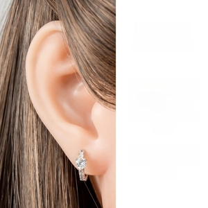 Detail of silver heart-shaped zircon hoop earrings shown on model with design concept