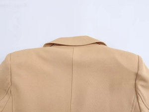 Detail of camel blazer neckline and back shoulder with high-quality fabric texture