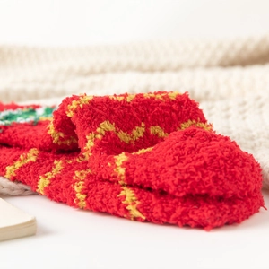 Gros plan de chaussettes de Noël en polaire corail rouge avec motifs de vagues jaunes