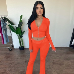 Detail of vibrant orange two-piece tracksuit set with v-neck zip top and flared pants