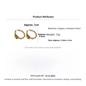 Detail showing gold-plated earrings with pearls, chain links, and a V-shaped centerpiece