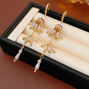 Détail de boucles d'oreilles bohèmes vintage avec perles et cristaux sur boîte à bijoux
