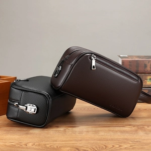 Close-up of black and dark brown lychee leather clutch bags with silver metal zippers