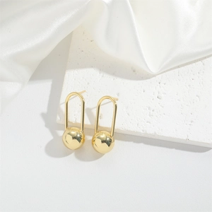 Detailed view of elegant gold oval drop earrings with polished sphere on white silk