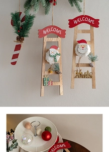 Detail view of a wooden Christmas hanging ornament featuring Santa and snowman figures