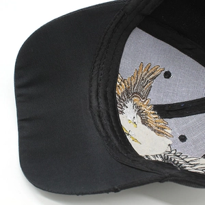 Close-up of eagle embroidery backing and neat stitching inside black cotton baseball cap