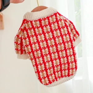 Detailed close-up of the red and brown knitted plaid texture on the pet dog sweater