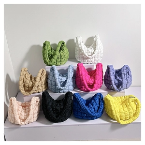 Collection of colorful quilted cloud bags in vibrant and pastel shades displayed on steps