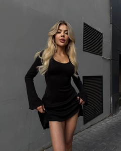 Vue de face d'une mini robe noire à manches longues moulante avec une encolure en U